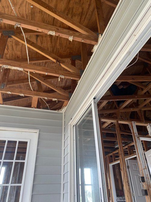 Exposed roof framing and siding during a storm reconstruction project.