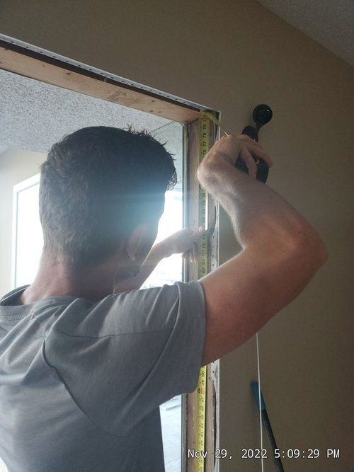 Crew member measuring a door frame during installation.
